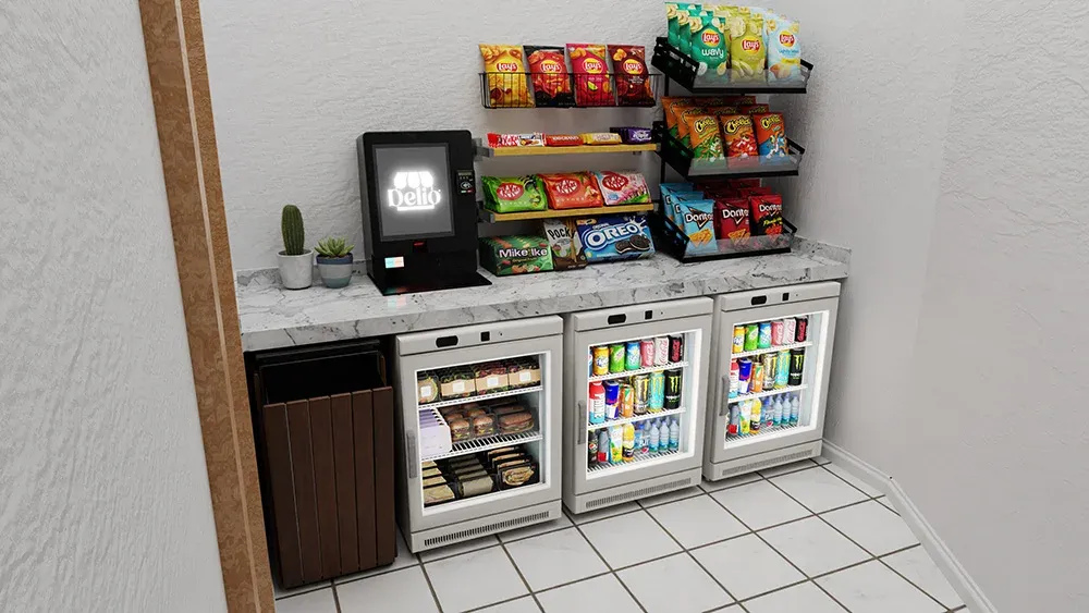 Compact office market counter with mini coolers, snack racks, and a Delio self-checkout kiosk