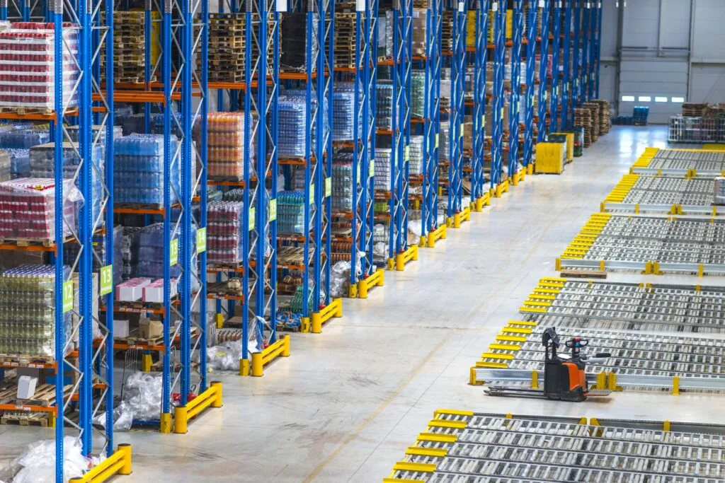 Distribution center aisles with tall pallet racks and a pallet jack