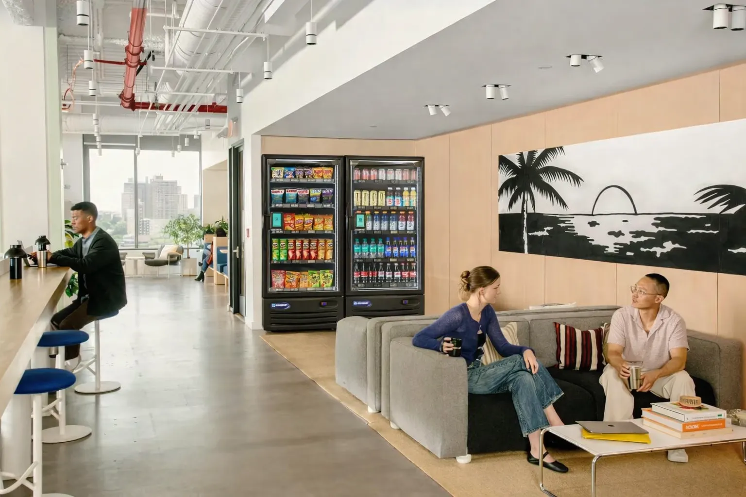 Office break room with smart vending coolers and coworkers on a break
