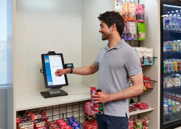 Man paying with a tap at a micro market self-checkout kiosk
