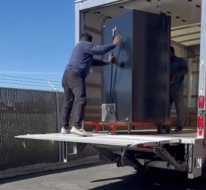 Mover securing a vending machine on a truck lift gate in Dallas Fort Worth