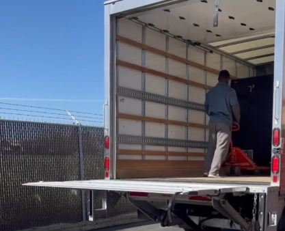 Mover using a pallet jack to position a vending machine inside a truck in Dallas Fort Worth