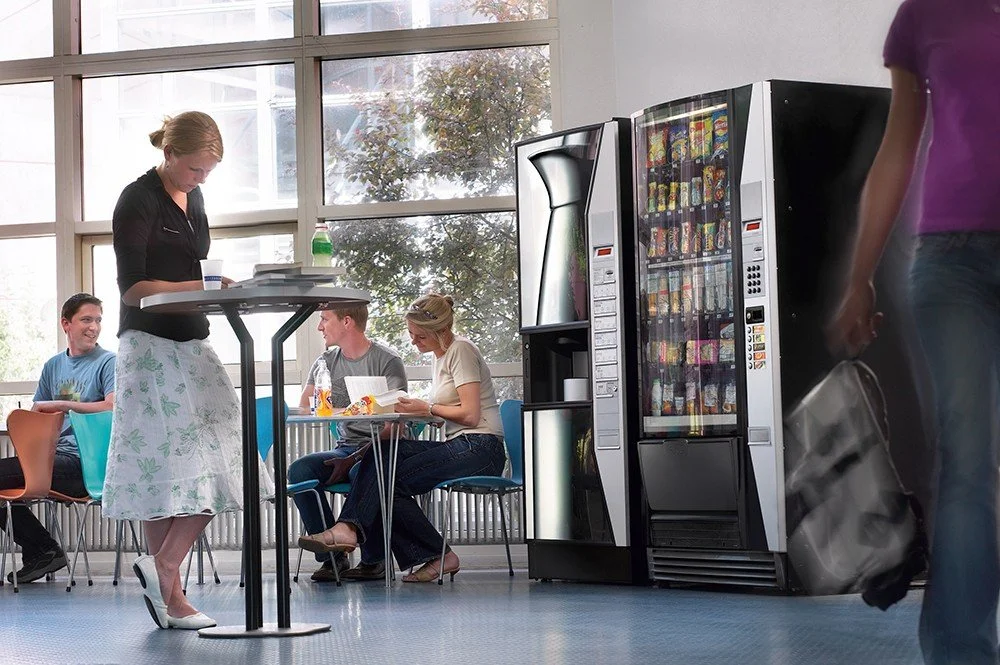 vending machine in the office breakroom with employees