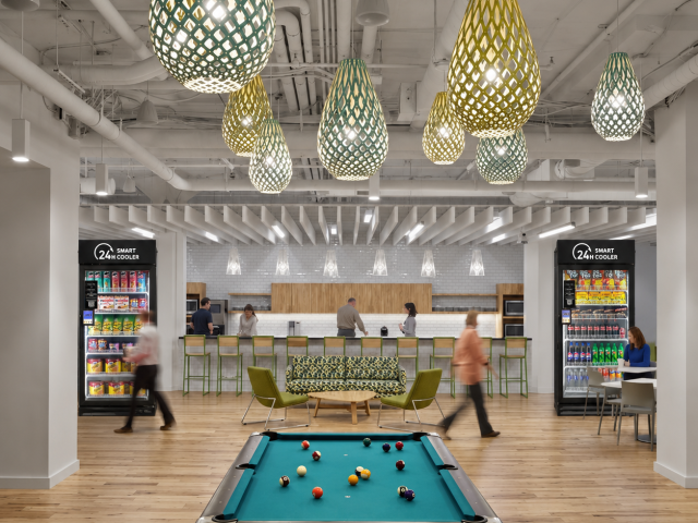 A clean warehouse employee breakroom with vending machines, smart coolers, coffee station, and workers on break.
