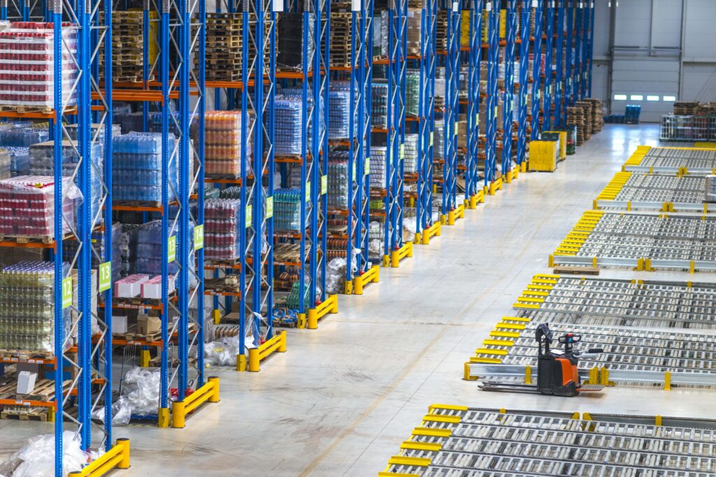 Forklift moving pallets in the background while employees work in a busy distribution facility.